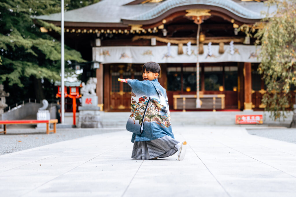 七五三で神社の前でポーズを決めている男の子の写真