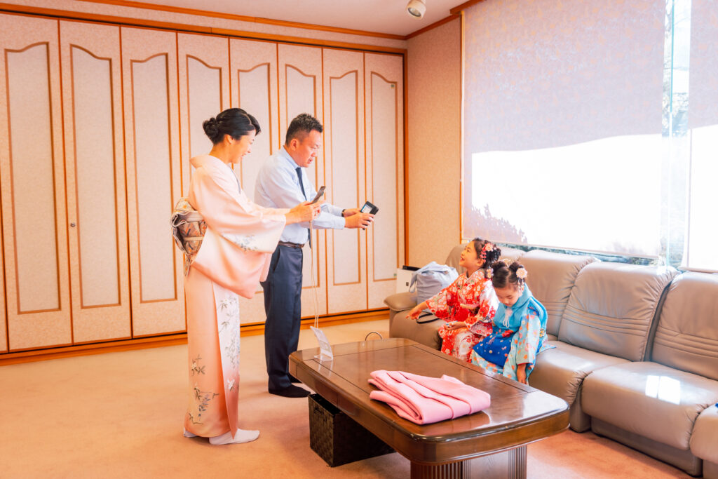 ７５３で着替えが終わった娘たちを両親が写真を撮っている様子の写真