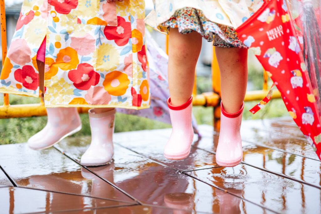 長靴を履いて水たまりの上をジャンプしている写真